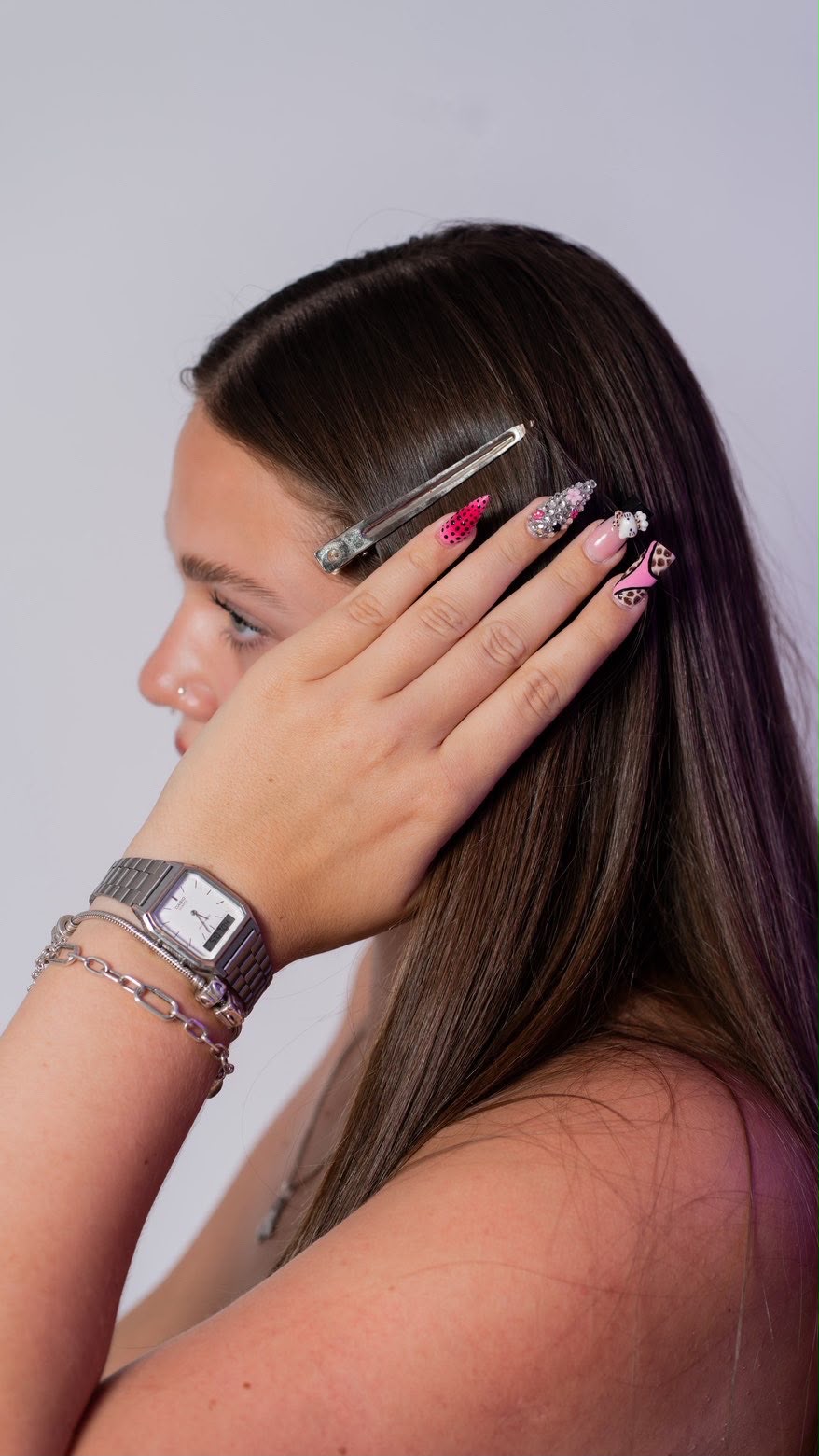 Hand im Haar mit Nail-Art: Pink mit Punkten, Strass, Charms und Leo-Muster